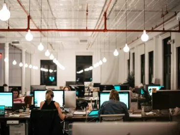 People working at a bank of desks in an office