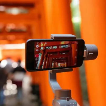 A mobile phone on a tripod capturing video.