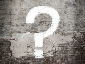 A question mark in graffiti on a wall