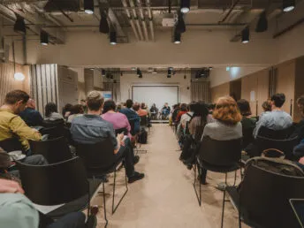The audience at the Mission Economy Summit. Photo taken from the back of the room, looking towards the speakers